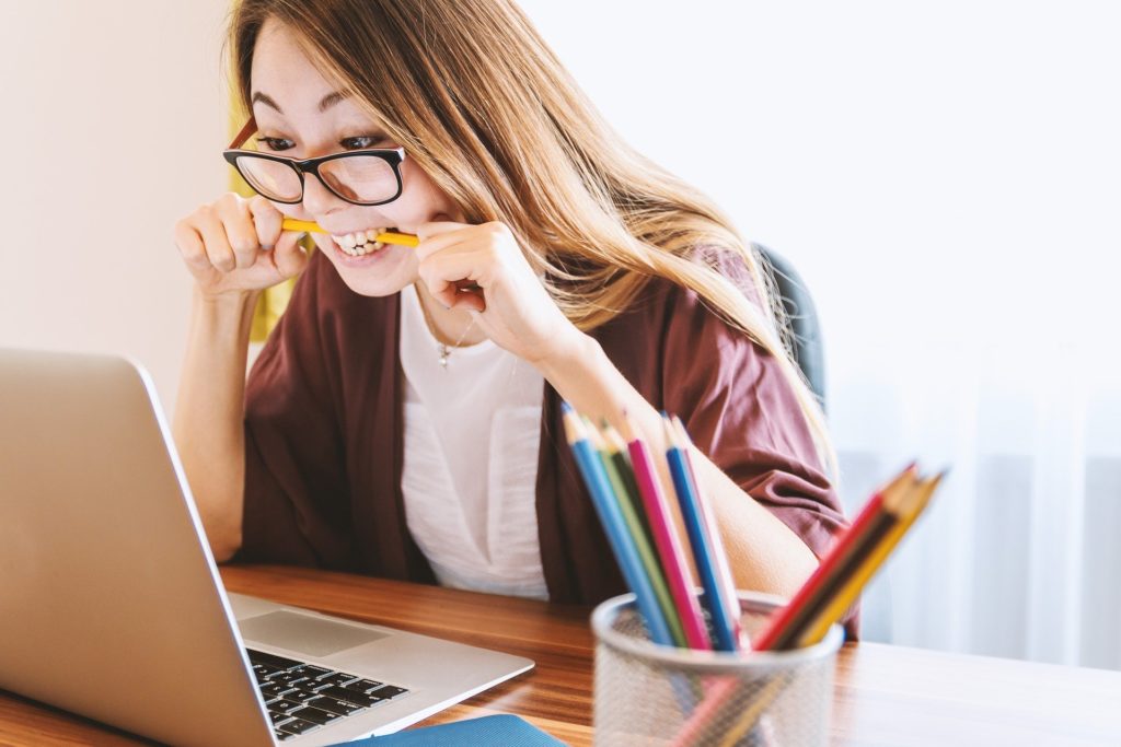 Stressed woman in front of laptop needing help to reach financial goals