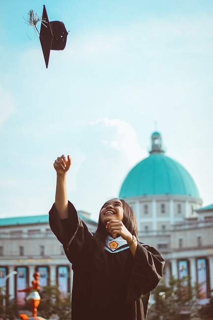 Graduate throwing cap into air